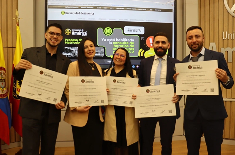 Graduados de la Universidad de América muestran sus certificados académicos en ceremonia oficial. Educación y empleo en Colombia