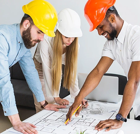 Especialización en Gerencia de Empresas Constructoras 2 Equipo de ingenieros trabajando en planos de construcción en la Especialización en Gerencia de Empresas Constructoras de la Universidad de América