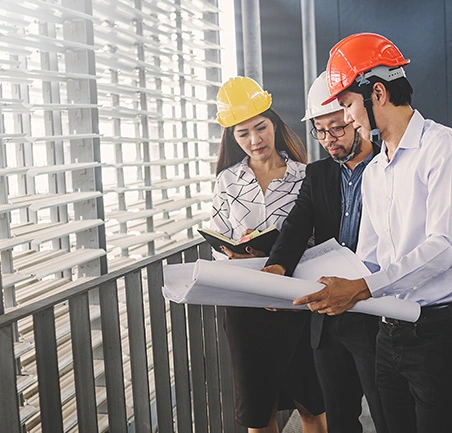 Especialización en Gerencia de Empresas Constructoras 4 Profesionales dirigiendo revisión de planos en la Especialización en Gerencia de Empresas Constructoras de la Universidad de América