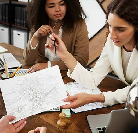 Especialización en Planeación Territorial 3 Profesionales revisando planos urbanos en la Especialización en Planeación Territorial de la Universidad de América