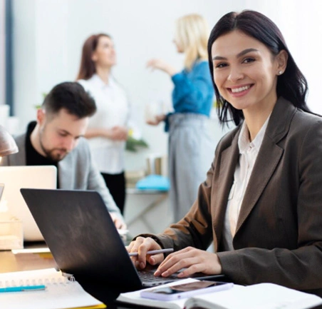 Profesional del MBA de la Universidad de América sonriendo mientras trabaja en un entorno empresarial.